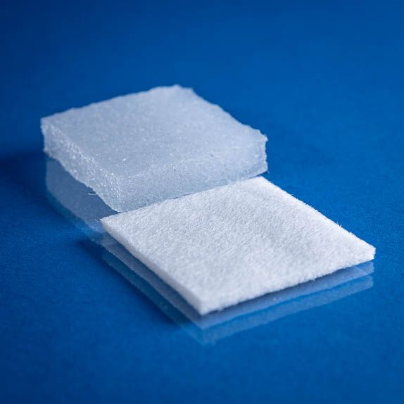 Type 2091 180gsm Superabsorbent Airlaid Thermally Bonded Nonwoven Fabric on a blue background. Image shows this fabrics superior absorption properties