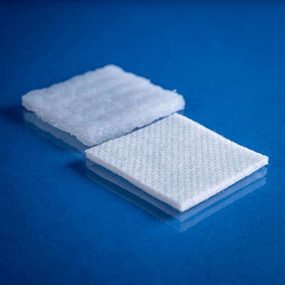 Type 2734 260gsm Washable Superabsorbent Needlepunch Nonwoven Fabric with top and bottom laminates shown on a blue background