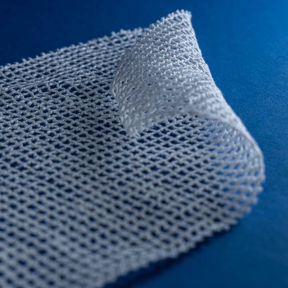 Type 2751 135gsm Superabsorbent Yarn Netting Fabric shown rolled on a blue background