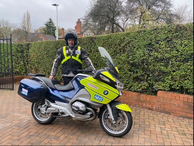 Commercial Director Volunteers for bloodline, stood with NHS bike