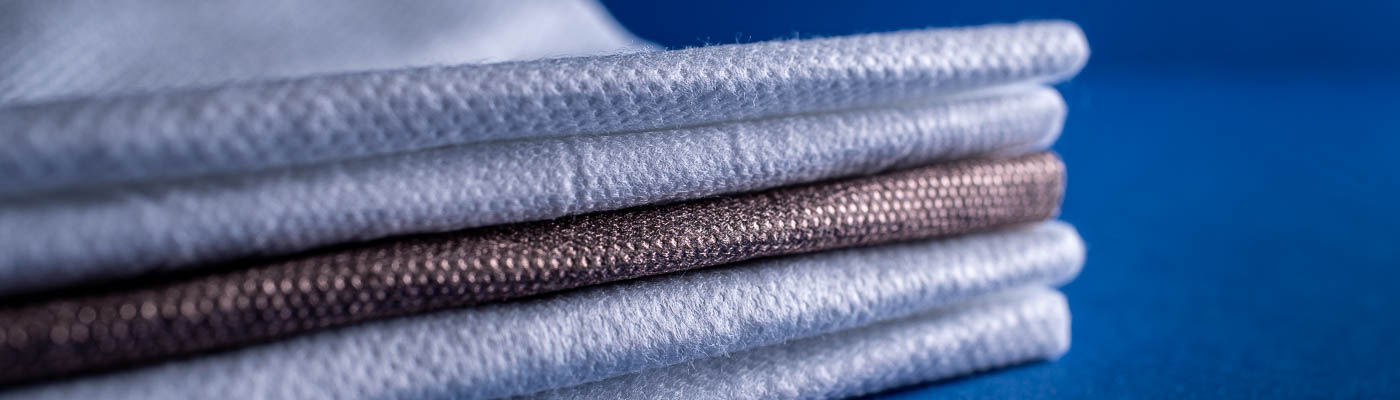 Technical Absorbents fabrics laid on top of each other on a blue background